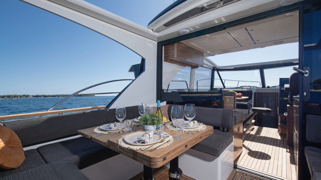 Sittbrunnen, med u-formad sittgrupp. På bilden också ett bord, uppdukat med glas och tallrikar, samt en flaska vin.