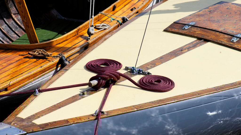 Lila tampar ordnade i två rundlar i fören på en träsegelbåt.