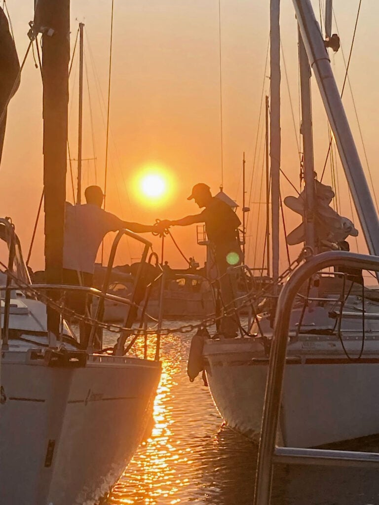 Bild i motljus från småbåtshamn. Många master.