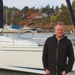 En man står på en brygga i en småbåtshamn.